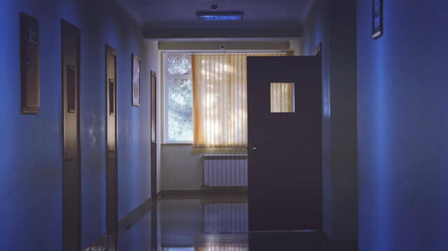 Отворена врата с прозорче в тъмен коридор
